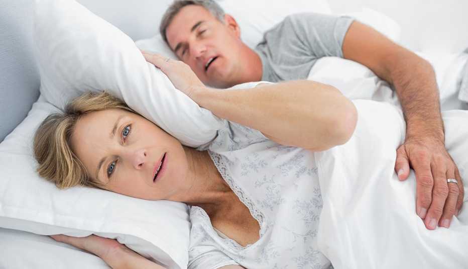 Couple asleep in bed with husband snoring