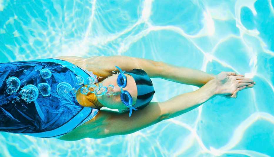 Woman swimming in pool with swim goggles
