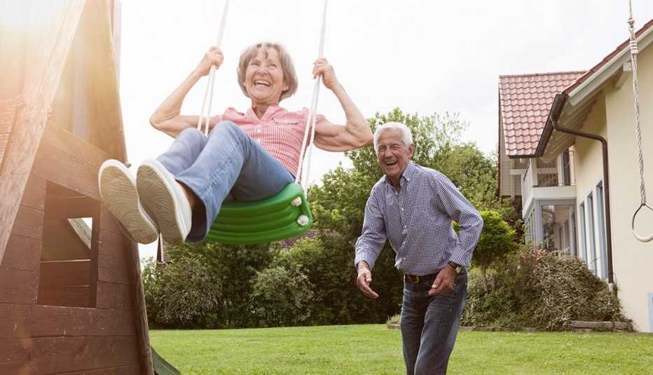 A playful couple playing with a swing in the backyard