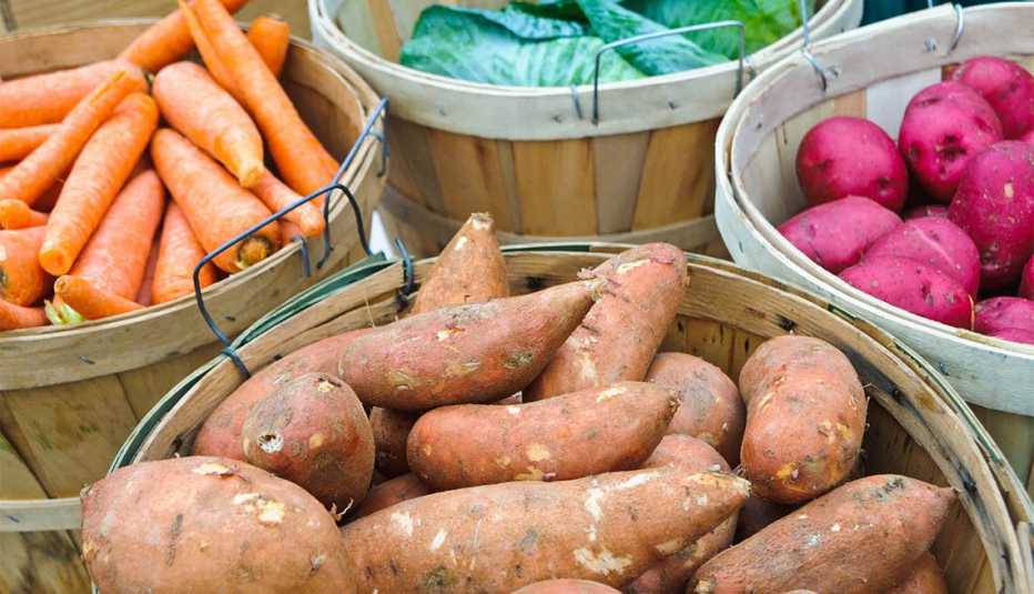 Bushel baskets of carrots, cabbage, red and sweet potatoes offered for sale and a midwinter farmers market on Cape Cod