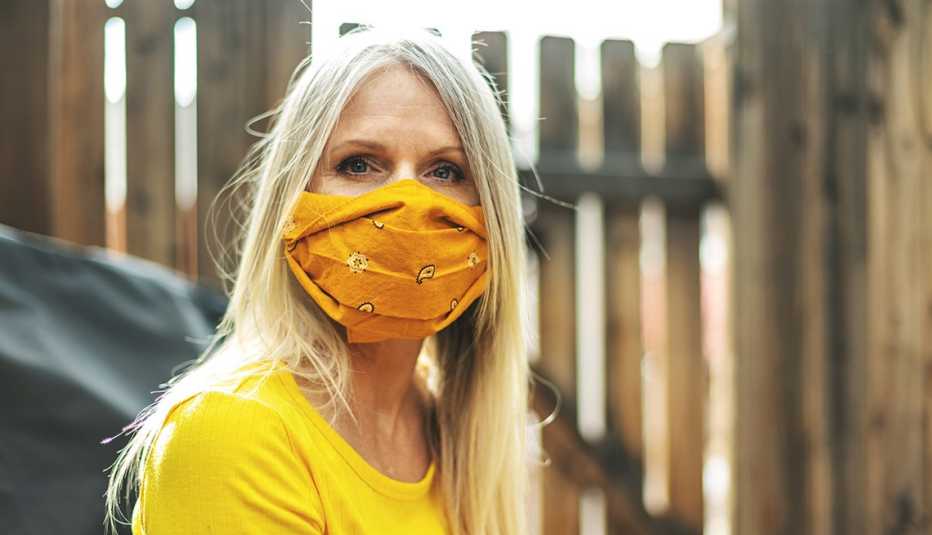 A woman wearing a yellow orange face mask