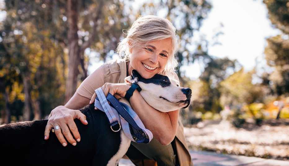 A woman embracing her dog during a walk in a park