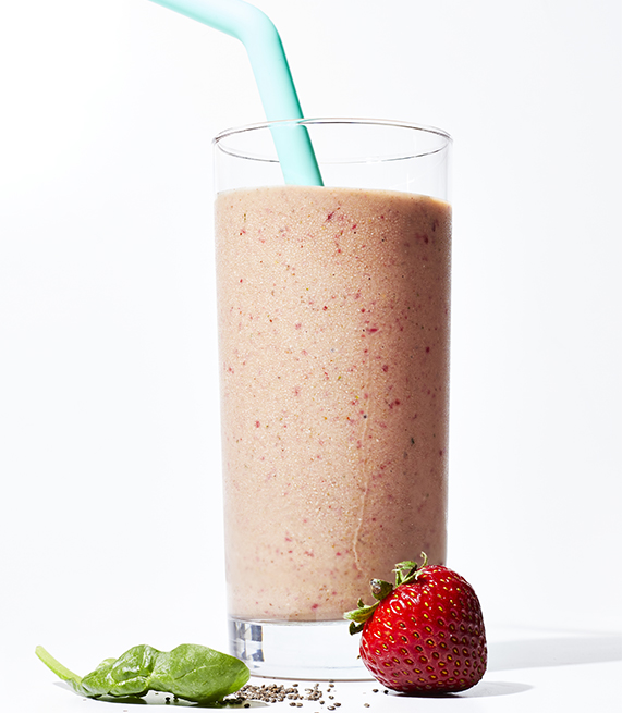 smoothie in tall glass with strawberry and greens