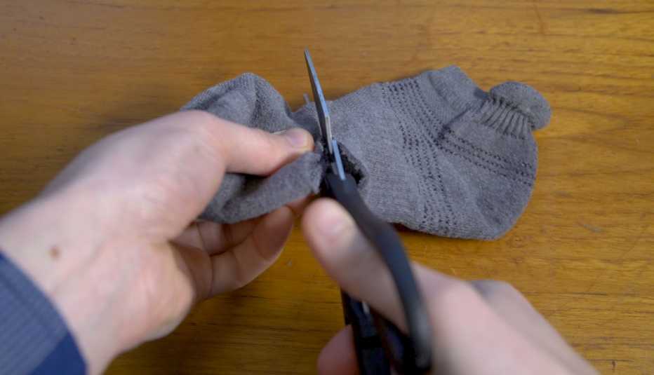 hands cutting off end of the sock