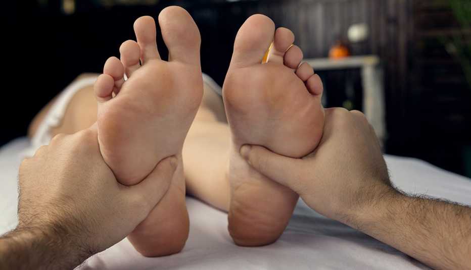 A massage therapist does a foot massage.