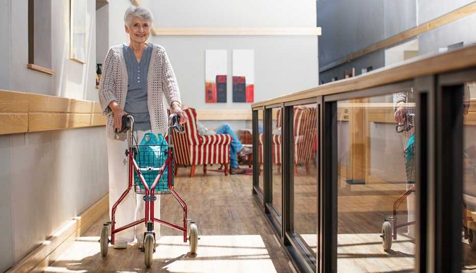 senior woman indoors using a three wheeled walker