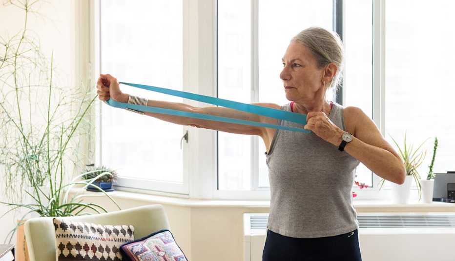 woman in her home using an exercise band