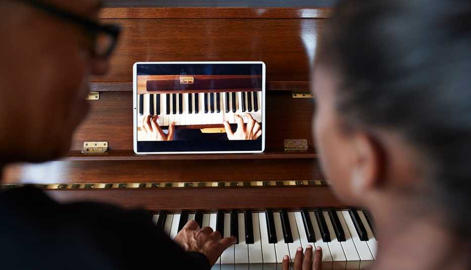 people taking a virtual piano lesson with their smart tablet