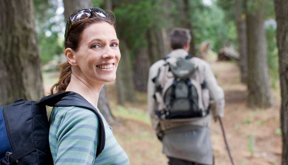 couple hiking in the woods, woman smiling at the camera