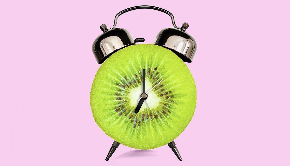 an alarm clock made out of a sliced kiwi to symbolize foods for sleep