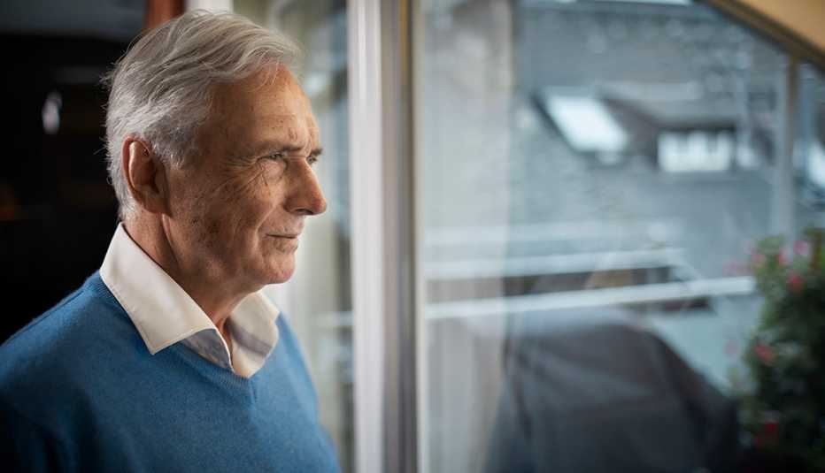 older man staring out of a window
