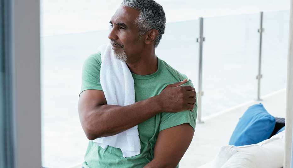 man rubbing his shoulder to relieve pain