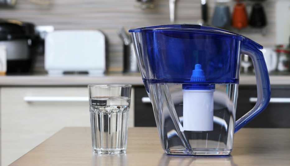 close up of a water filter pitcher and water glass on a kitchen counter