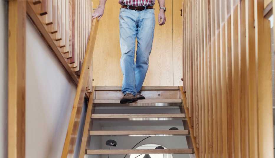 a man walking down the stairs in his house