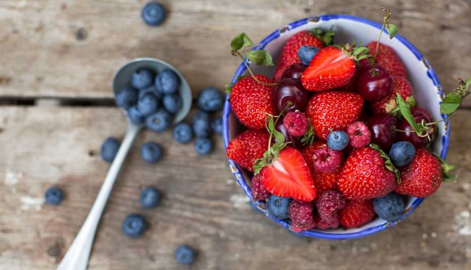 strawberries, raspberries, blueberries, and cherries in a bowl