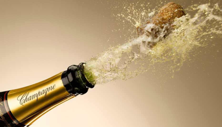 close up of champagne and cork exploding from bottle