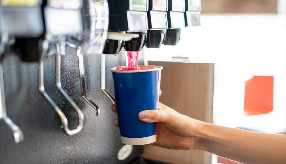 hand pouring a fizzy drink from soda fountain