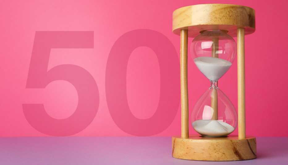 hourglass with flowing sand on violet table against pink background with the number fifty to symbolize menopause