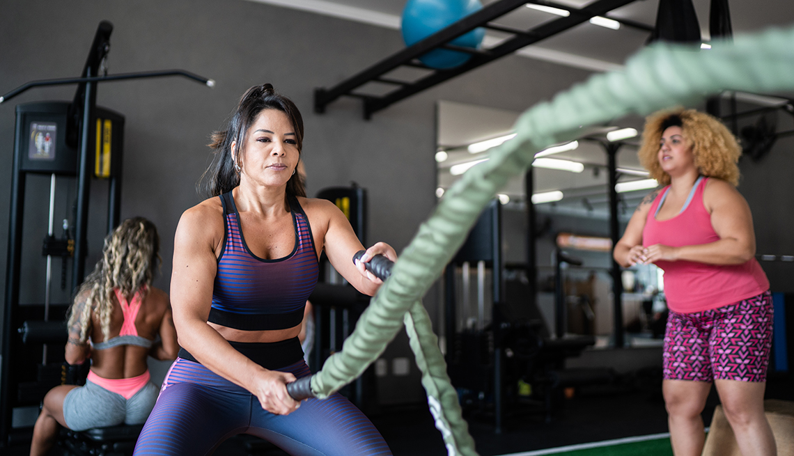 woman at the gym working out with battle ropes in the fat burning zone to torch more calories and unhealthy fat