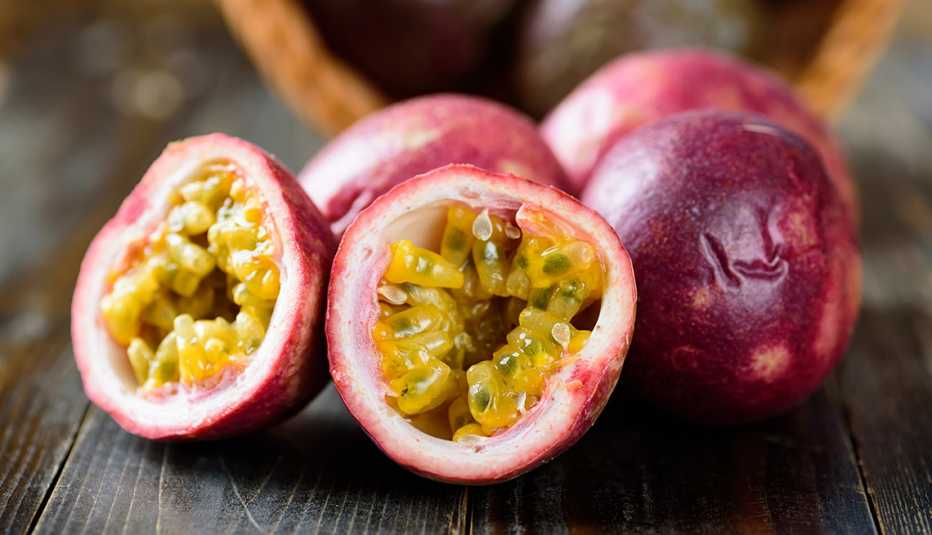close up of high-fiber passion fruits sliced in half on a wooden background