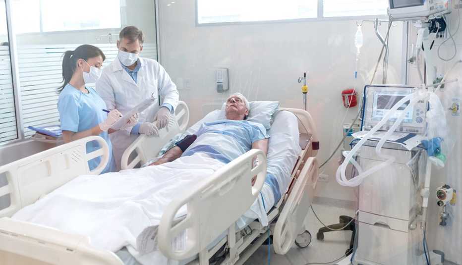 Doctors discussing a patient's case at his hospital bed. 