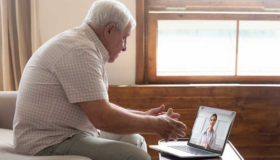 A man talks with his doctor on a laptop