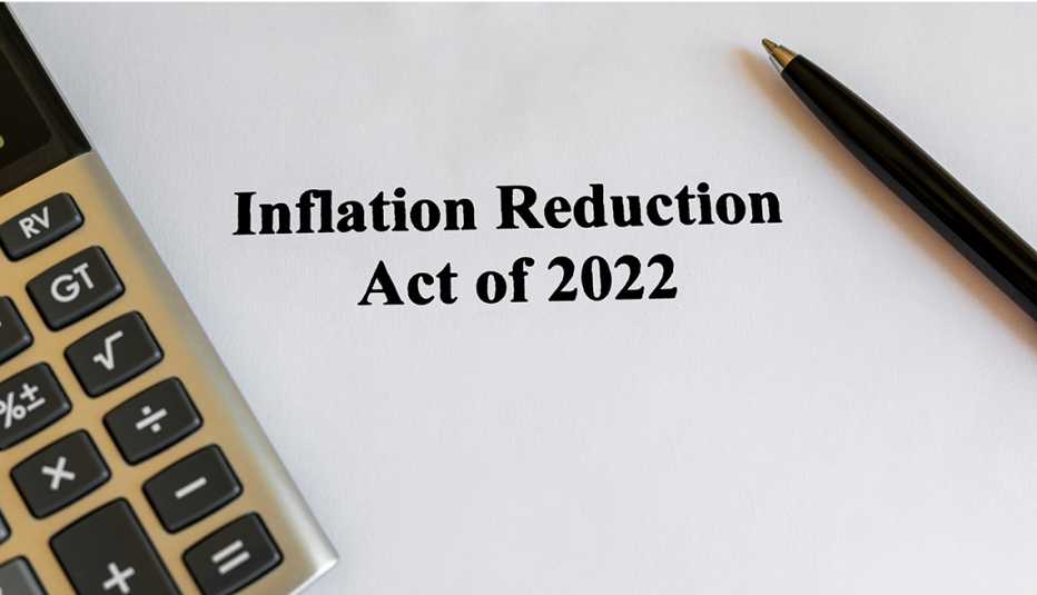 the words inflation reduction act of 2022 printed on a piece of paper and a calculator and pen nearby