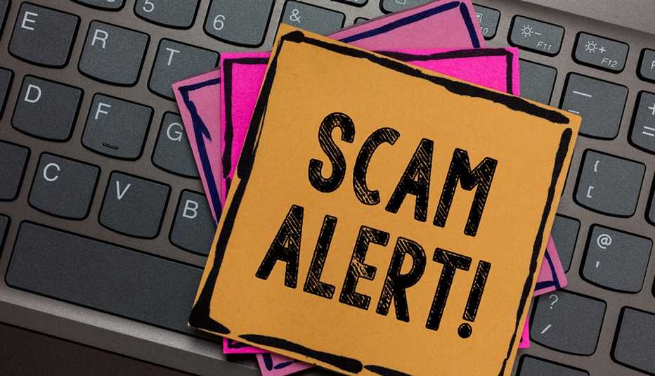 post-it notes on top of a keyboard with the words Scam Alert!