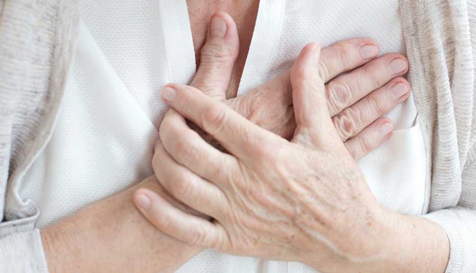 A close up of a woman's hands holding her chest