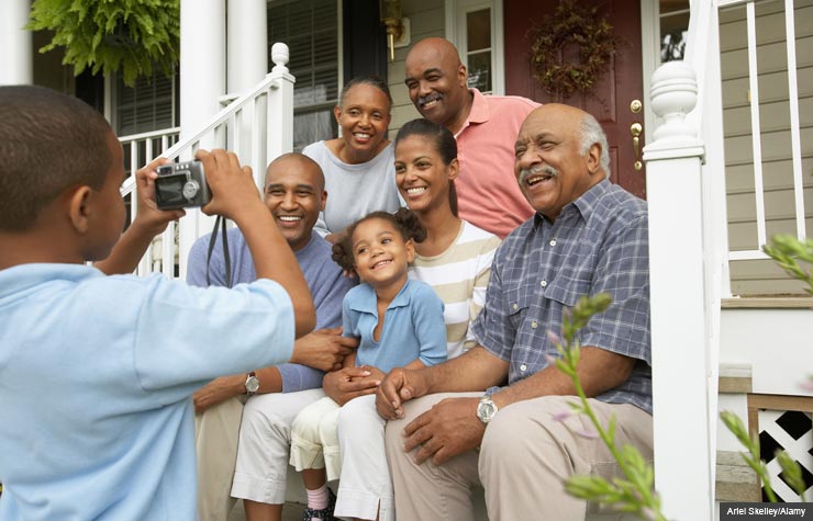 Boy takes photo of family on porch. How to create an oral family history. (Ariel Skelley/Alamy)