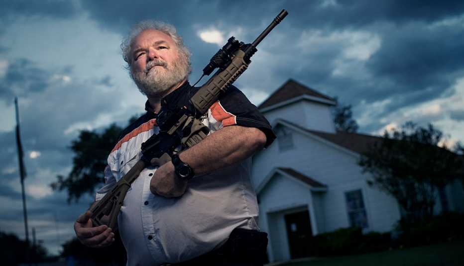 Stephen Willeford holding a gun in front of a church