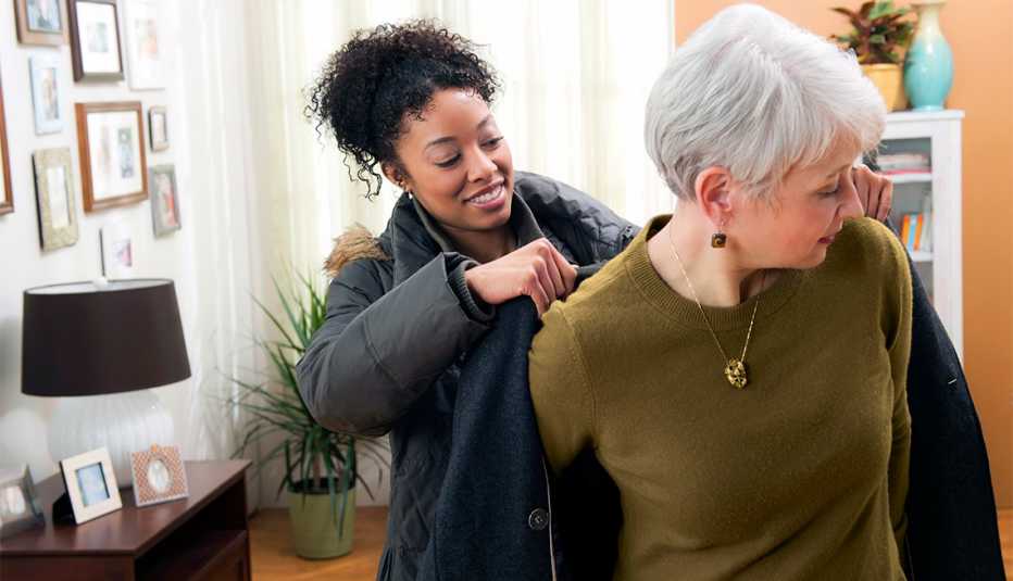 Woman helping older woman with coat