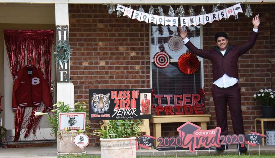 Jonathan Nieves smiles on his porch, decorated with 2020 Grad memorabilia 