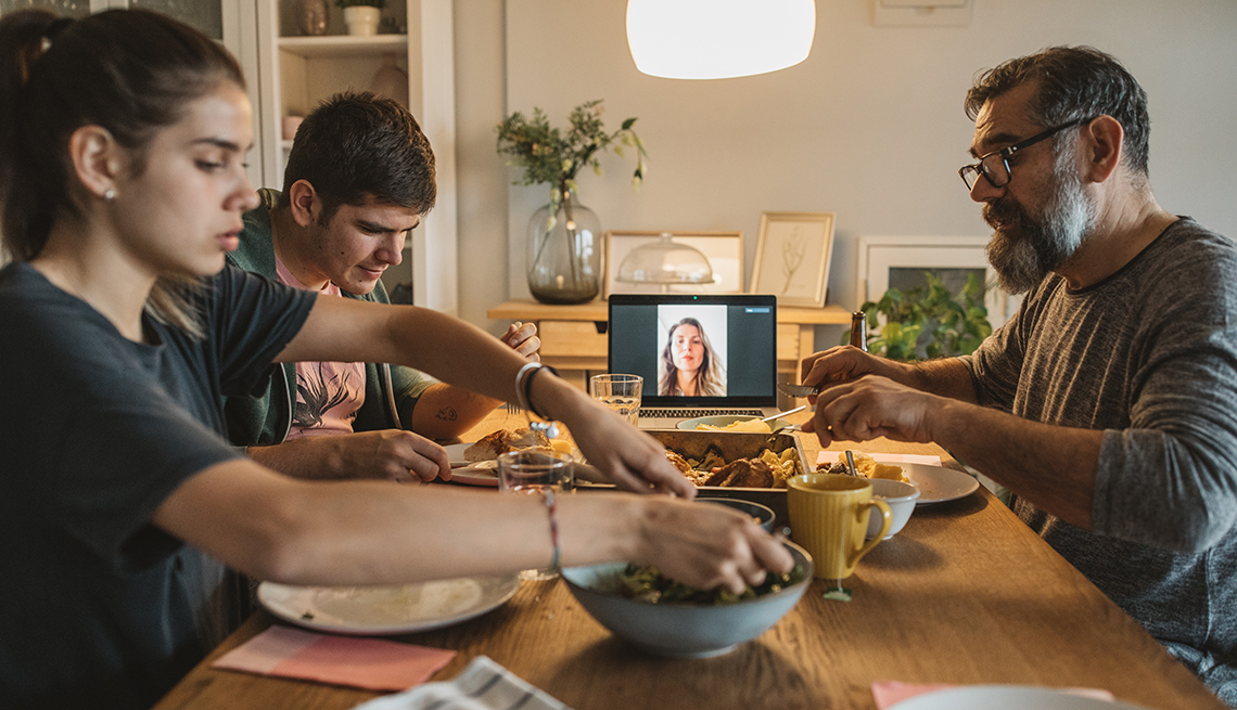 Family having dinner with mother on a tablet screen