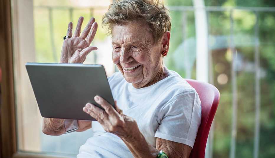 A mature woman using digital tablet on apartment balcony 