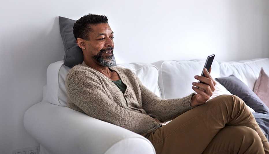 Man smiling, laughing at smartphone