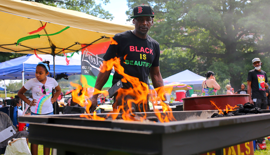a man prepares a barbecue at a juneteenth celebration in boston