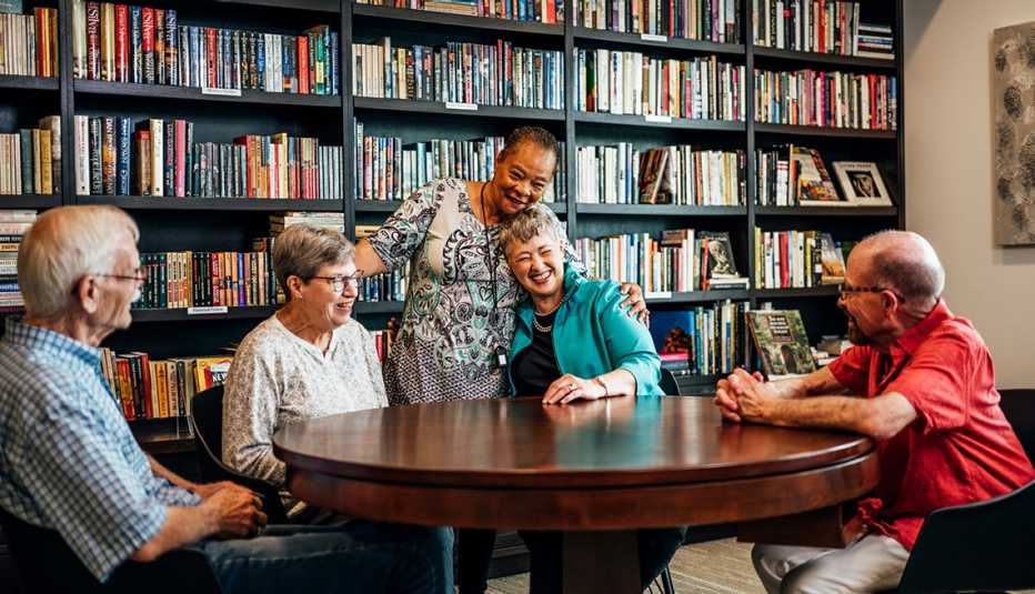 sitting at a table in a library room are from left to right tom bertram debbie deacon ruth jones anise parker who is standing and barry pitts