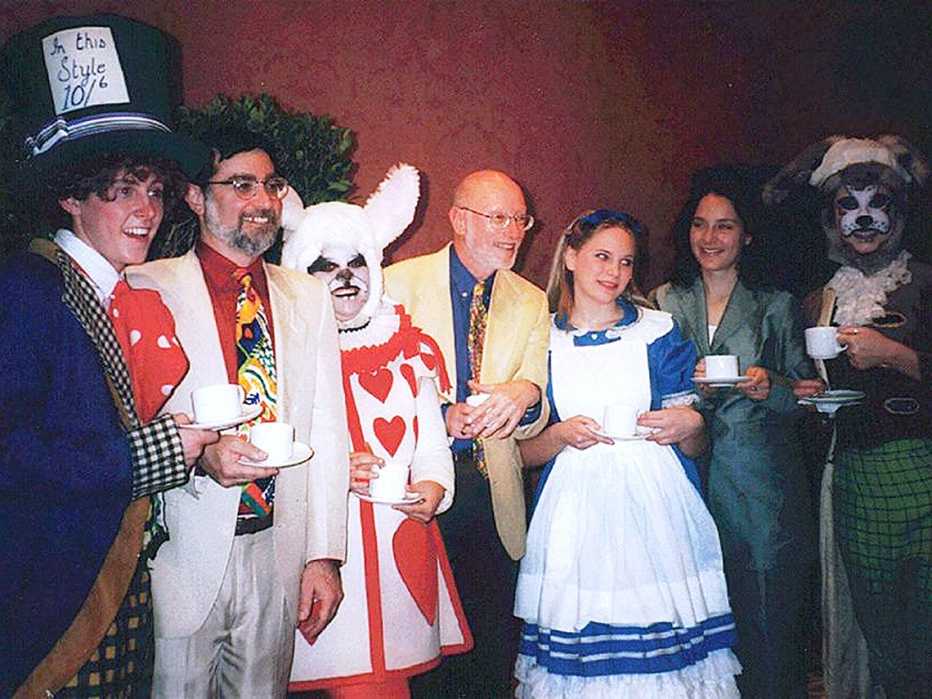 a group of seven people wearing alice in wonderland costumes