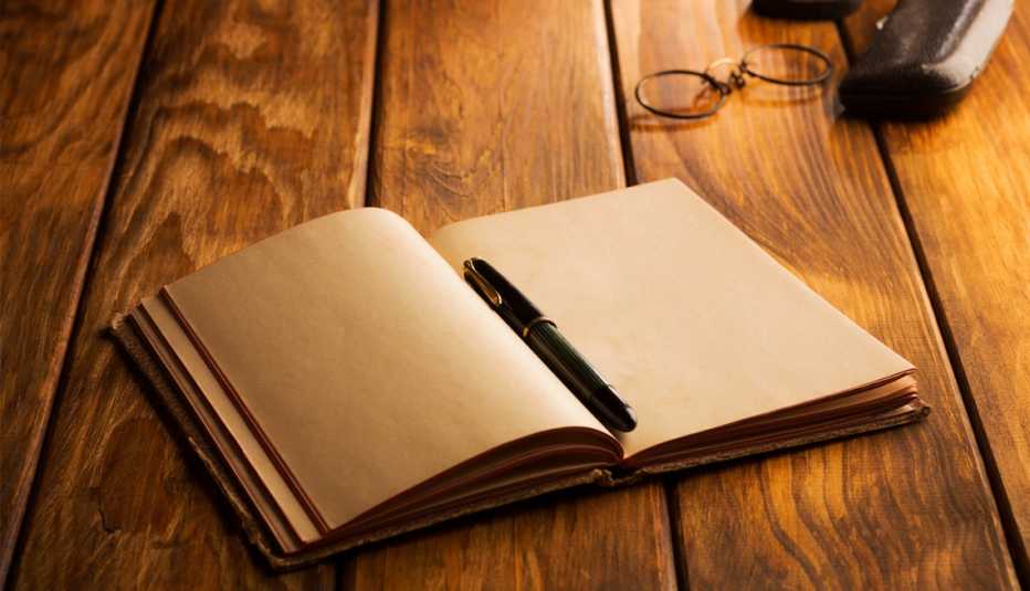 a pen on a journal with glasses