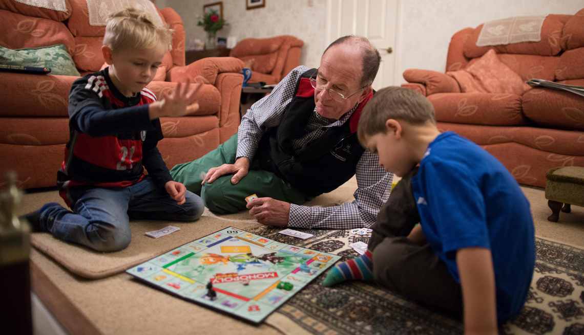 a grandfather and his grandsons playing monopoly
