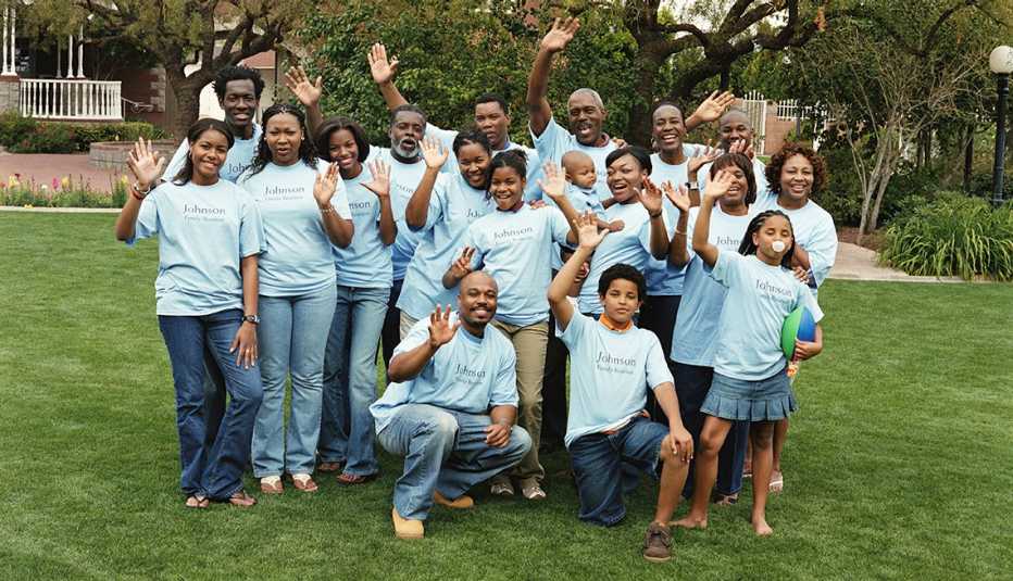 large multi generational family all waving and wearing tee shirts that say johnson family reunion
