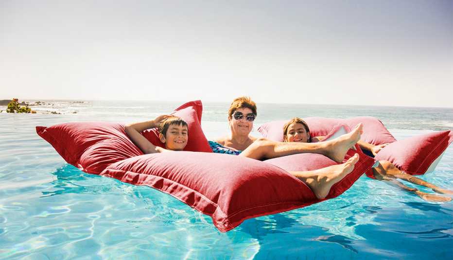 Grandmother and grandchildren relaxing on pool raft