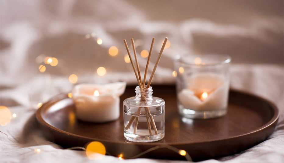 Home perfume in glass bottle with wood sticks and candles