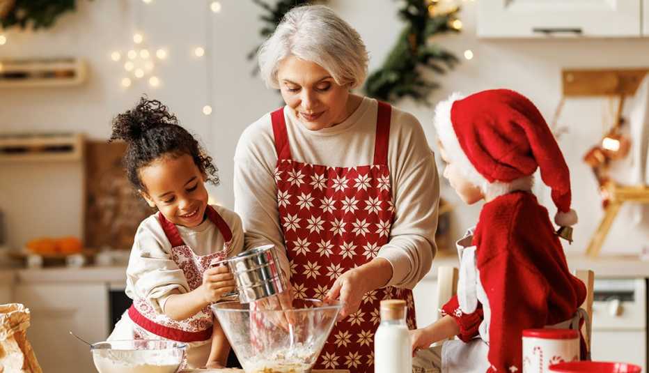 a grandmother baking cookies with her two grandkids