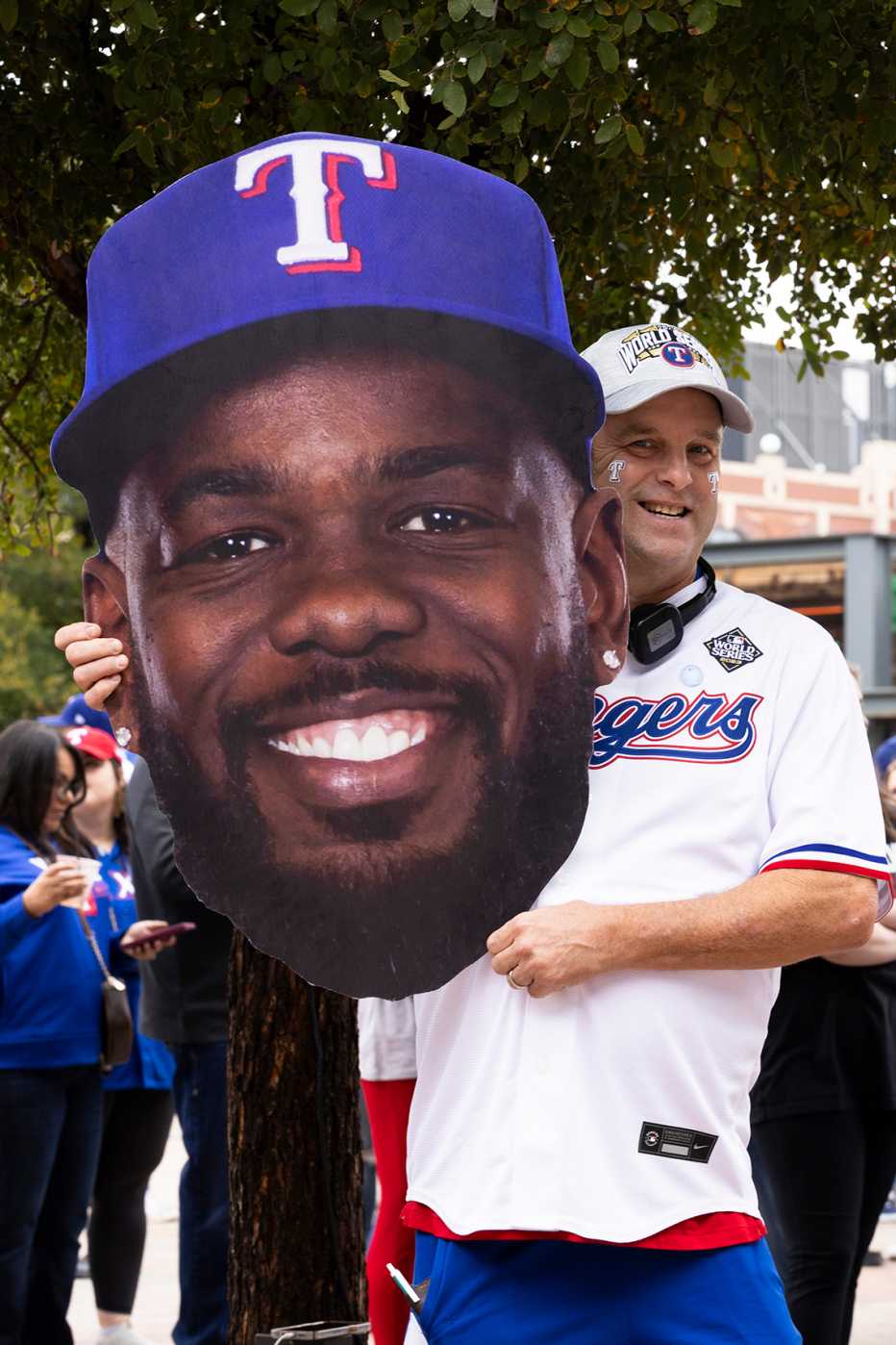 phil schirmer standing with an over sized cut out of ranger outfielder adolis garcia