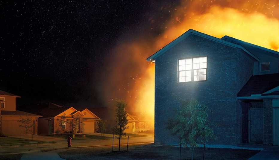 a house on fire at night time as seen from outside