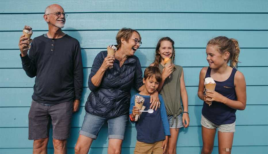 family members smile while they eat ice cream together
