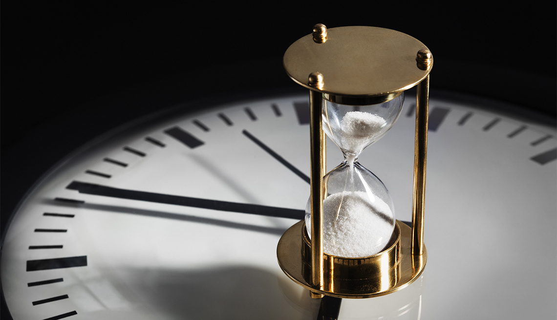 An hourglass resting on a clock face