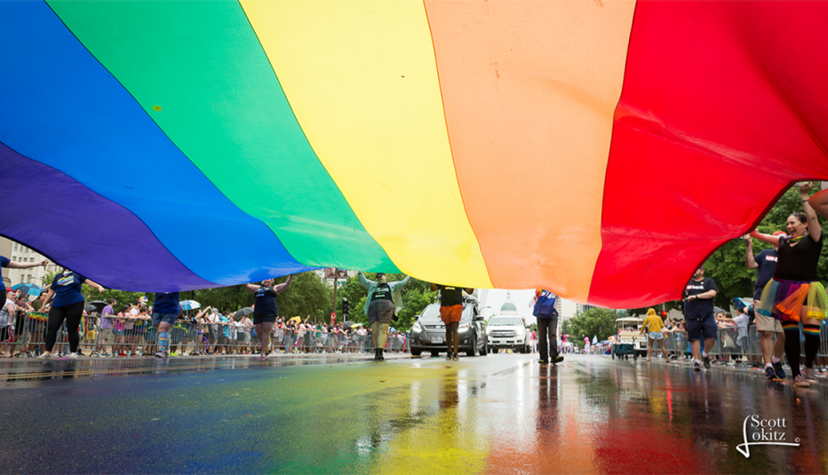 people marching holding an oversize rainbow flag at saint louis pridefest in missouri